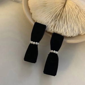 Close-up of black velvet bow hair clips with elegant pearl embellishment detail