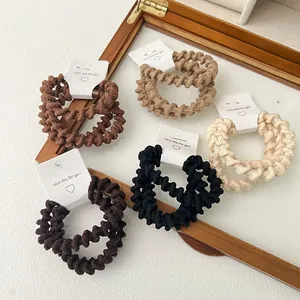 Close-up of spiral elastic telephone wire hair ties in various earthy colors on card