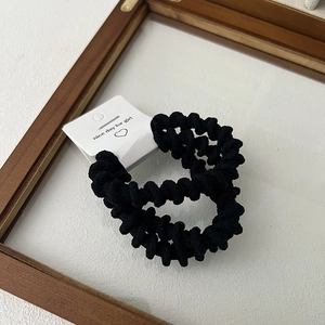 Set of black spiral hair ties with high elasticity on a card in a wooden frame