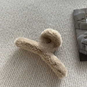 Gros plan sur la pince à cheveux en peluche marron clair avec fourrure douce