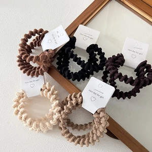 Five-pack of earthy-toned spiral telephone wire hair ties on minimalist cards