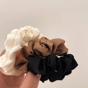 Three-piece set of satin scrunchies in cream brown and black colors for women