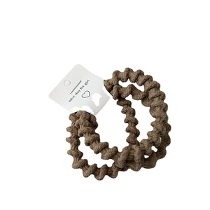 Set of two elastic spiral hair ties in coffee color with premium knit texture on white background