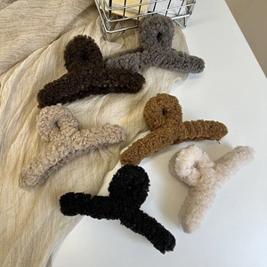 Plush faux fur claw clips in six colors for elegant winter hair styling on a white surface