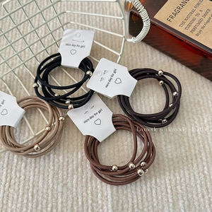 Set of 5 high elasticity hair ties with metal beads in neutral tones on a display card