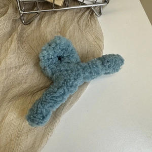 Detail view of large blue fuzzy lamb wool claw clip showing thick plush texture and shark clip design