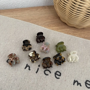 Set of nine mini acetate hair claws in assorted marble and tortoise patterns