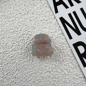 Macro view of handmade acetate mini hair claw clips in colorful marbled pastel tones