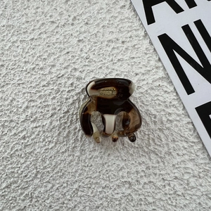 Close-up of small acetate hair claw with brown amber texture and handmade engraving