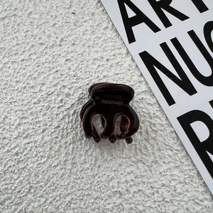 Detail view of handmade tortoiseshell hair claw clip with golden France logo print