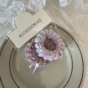 Close-up of fuzzy plush telephone wire hair ties in solid purple and mixed pink colors