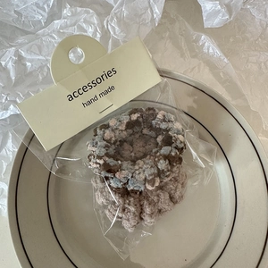 Detail view of two plush teddy fleece telephone wire hair ties on a white ceramic plate