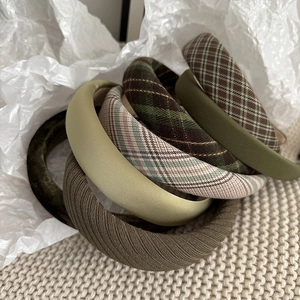 Close-up of textured dark green velvet and plaid sponge headbands set for women