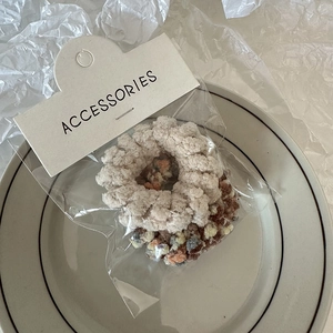 Detail of plush telephone cord hair ties in beige and brown colors on a ceramic plate