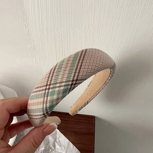 Detailed shot of retro padded sponge headband with beige and green plaid fabric texture
