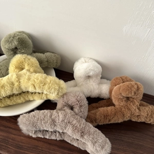 Nahaufnahme flauschiger Plüsch-Haarklammern in Farben wie Grün und Beige