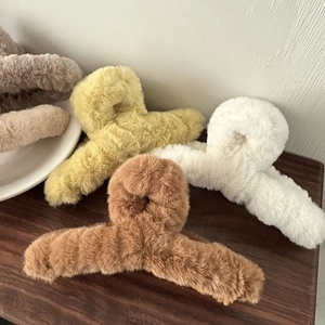 Detailansicht von flauschigen Haarklammern aus Plüsch in Braun, Creme, Weiß und Grau