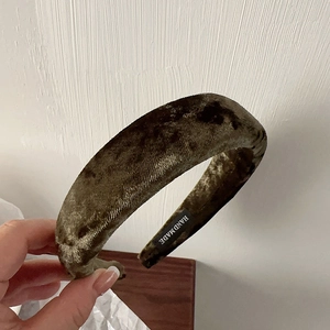Detail view of handmade dark green velvet padded headband with textured fabric finish