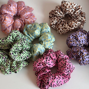 Vue détaillée de six chouchous en satin imprimé léopard coloré avec une texture soyeuse