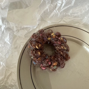 Gros plan d'un chouchou marron en peluche avec des boules colorées sur un plat en céramique