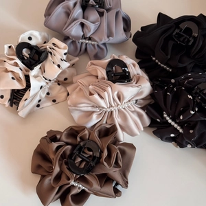 Close-up of elegant silk satin hair claws with polka dots and white pearl edge details