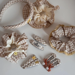 Detail view of yellow plaid fabric hair scrunchies and accessories with handmade label