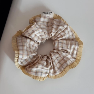 Detail of yellow checkered fabric scrunchie with lace trim and handmade label