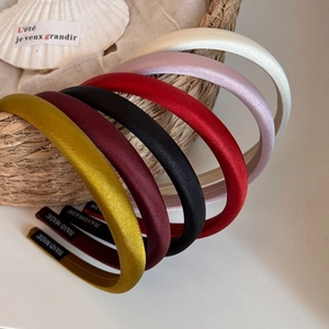 Détail de serre-têtes en velours colorés avec étiquette faite main au style rétro