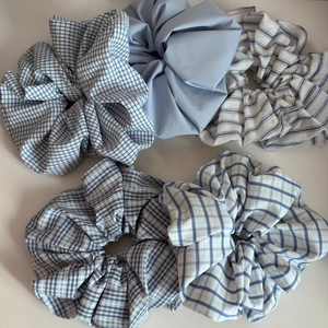 Flat lay of blue and white plaid scrunchies in various patterns and textures