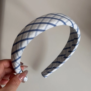 Close-up of blue and white plaid fabric texture on wide padded headband accessory