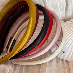 Vue détaillée de serre-têtes en satin rembourrés colorés avec étiquettes faites à la main