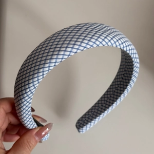 Detail of blue and white plaid fabric headband showing thick padded texture and Vichy pattern