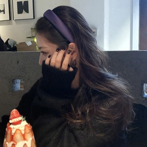 Close-up of soft purple satin scrunchie worn by a model in a cozy cafe setting