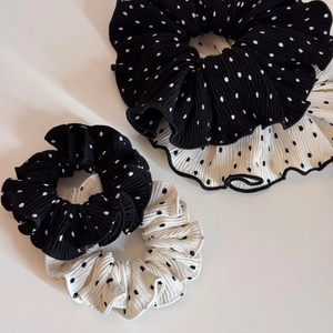 Close-up of black and white polka dot pleated scrunchies set in two different sizes