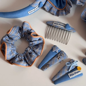 Detailed flat lay of blue plaid hair accessories set including star clips and scrunchie