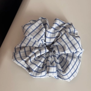 Detailed view of the blue and white checkered plaid fabric texture on a scrunchie