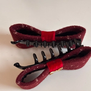 Detailed close-up of bow banana clips with red embroidered fabric and black plastic teeth