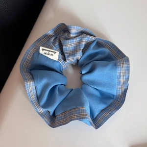 Detailed macro view of handmade blue checkered scrunchie with a stitched label
