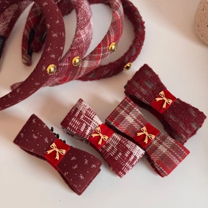 Detailed view of red checkered bow hair clips and headbands with golden metal accents