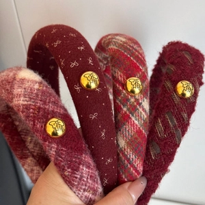 Macro detail of red knitted bow banana clips with textured fabric and golden buttons