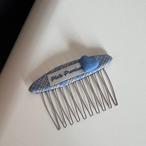 Detail of blue plaid fabric hair clip with velvet heart and metallic comb teeth