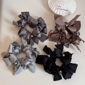 Lot de quatre chouchous nœuds avec perles argentées sur fond minimaliste élégant