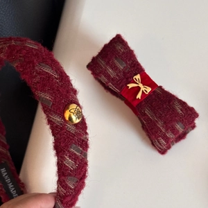Detail of red tweed headband and bow clip set with golden butterfly emblems
