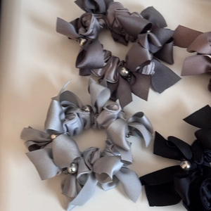 Détail d'élastiques en satin avec nœuds et perles grises pour coiffures élégantes