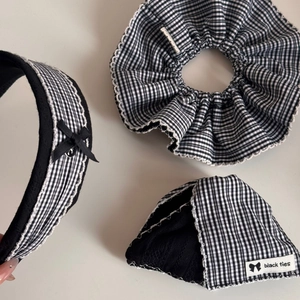 Detailed view of black and white plaid hair accessories with delicate white lace trim