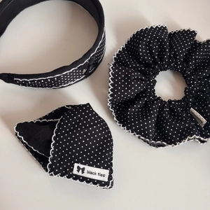 Detail view of black polka dot hair accessories set with white scalloped edge stitching