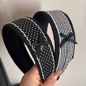 Close-up of black and white polka dot and plaid headbands with ribbon bows and metal studs