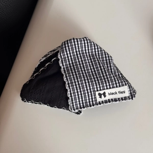 Close-up of black and white checkered fabric with contrast stitching and branded label