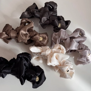 Detailed top view of five elegant satin bow hair claw clips in various neutral colors