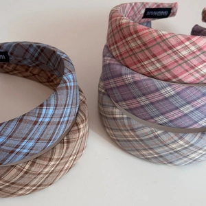 Detailed macro view of wide plaid headbands with handmade label and linen texture